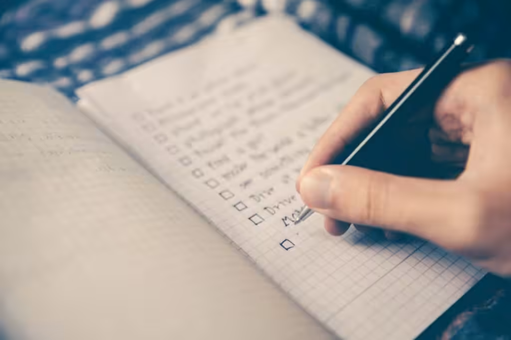 Handwriting checklist with pen on notebook.