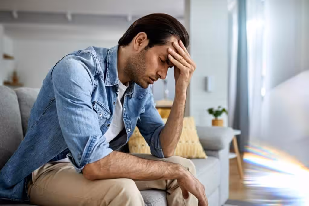 Man expressing stress or headache at home.