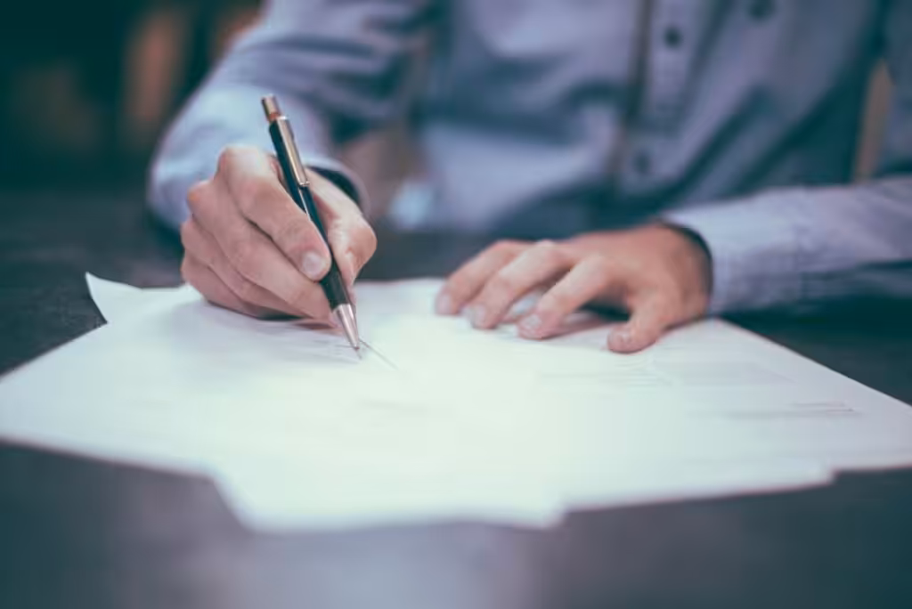 Person writing on paper with pen, close-up